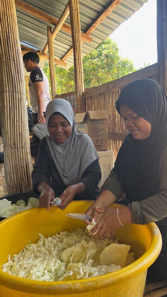 Volunteers preparing fresh vegetables for meals during a community outreach activity in Sungai Siput.