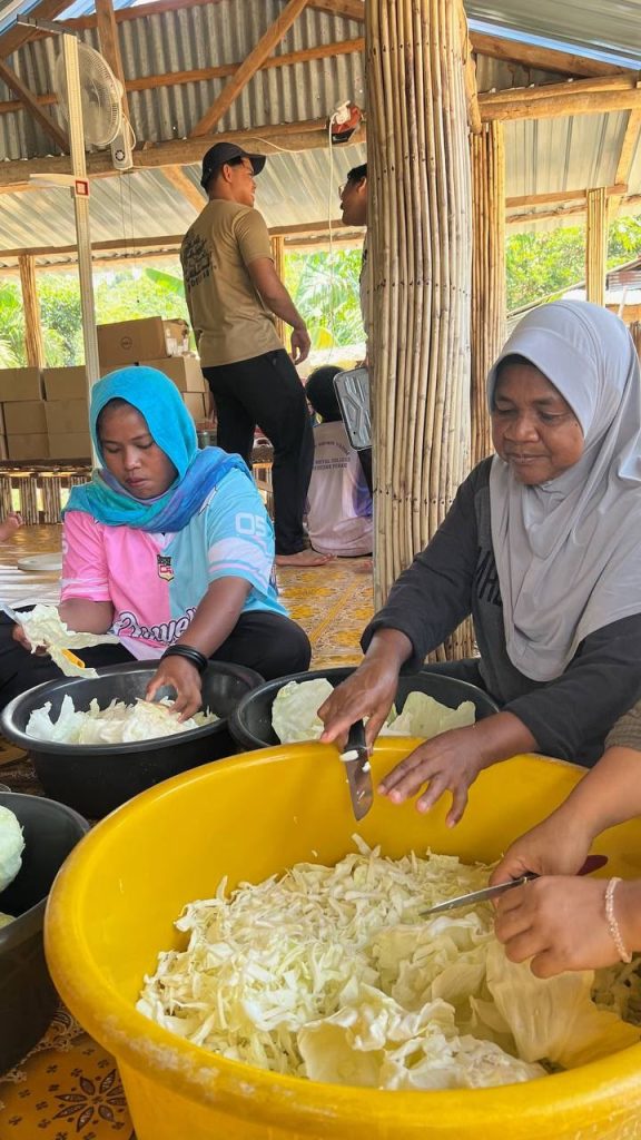 Students and volunteers preparing food for the Santuni Orang Asli community programme.